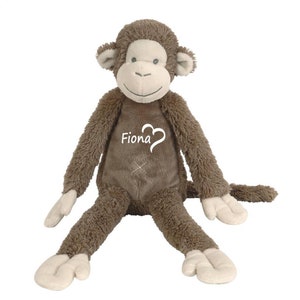 Op de afbeelding: Bruin pluche apen speelgoed met een wit hart en de naam "Fiona" geborduurd op zijn borst.