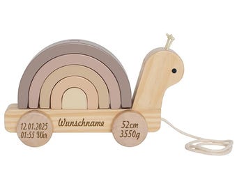 Könnte beinhalten: Ein hölzernes Ziehspielzeug in Form einer Schnecke mit einem Regenbogenbogen auf dem Rücken. Die Schnecke hat eine Schnur befestigt und die Räder haben die Gravuren "12.01.2025 01:55 Uhr", "Wunschname", "52cm 3550g".