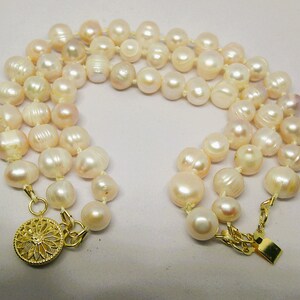 Peut inclure: Un collier de perles multi-rangs avec un fermoir en or. Les perles sont de couleur blanche et cr&egrave;me et ont un l&eacute;ger reflet iris&eacute;.