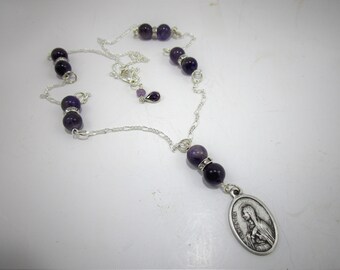 Collier de 60 cm environ en perles d'amythyste véritable et sainte Monique, patronne des alcooliques. Chaîne lourde SP Figaro. Médaille et chaîne fabriqués en Italie