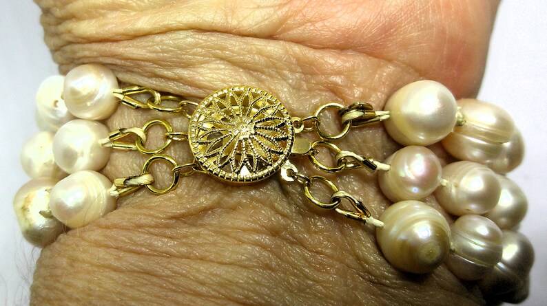 Peut inclure: Un bracelet en perles multi-rangs avec un fermoir en or orn&eacute; d'un motif floral.