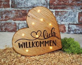 Heart made of oak wood with welcome lettering and LED lighting