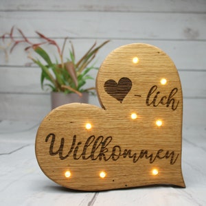Heart made of oak wood with the word Welcome and LED lighting