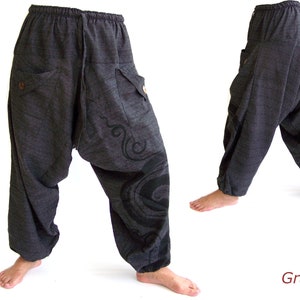 May include: Gray, loose-fitting pants with a drawstring waist and a decorative design on the leg. The pants have two large pockets on the front.