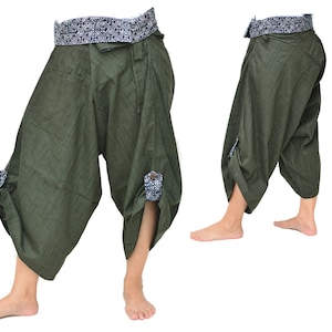 May include: Green cotton pants with a patterned waistband and button details on the legs. The pants are loose fitting and have a wide leg.