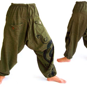 May include: Green, loose-fitting pants with a black and white design on the side. The pants have a drawstring waist and pockets.