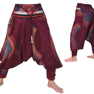 May include: Burgundy-colored pants with a colorful swirl pattern and a decorative waistband. The pants have a loose, flowing fit and are gathered at the ankles.