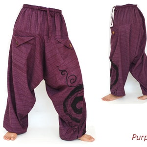 May include: Purple cotton pants with a swirling design on the right leg. The pants have a drawstring waist and two pockets on the front.