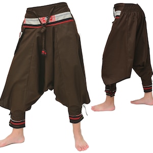 May include: Brown cotton pants with a wide leg and a gathered waist. The pants have a red, white, and blue patterned waistband and matching trim at the ankles.