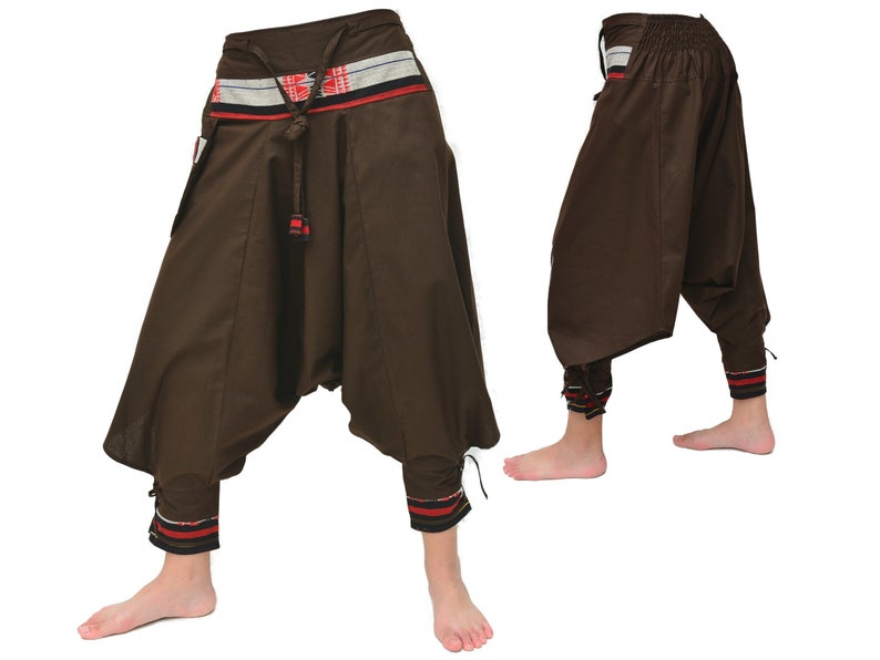 May include: Brown cotton pants with a wide leg and a gathered waist. The pants have a red, white, and blue patterned waistband and matching trim at the ankles.
