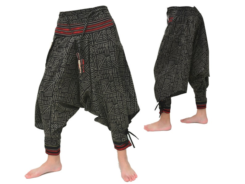 May include: Black and gray patterned pants with red and white trim. The pants have a loose, baggy fit and are gathered at the ankles with drawstrings.