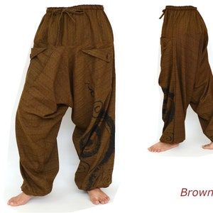 May include: Brown, loose-fitting pants with a drawstring waist and a black swirl design on the right leg. The pants are made of a soft, comfortable fabric.
