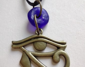 Eye of Horus Pendant: Bronze Egyptian Amulet, Blue Glass Bead, Leather Cord