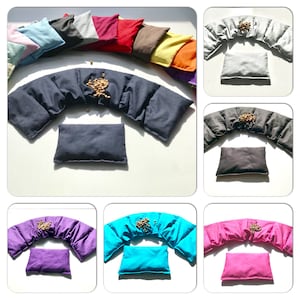 Könnte beinhalten: Ein Set mit 10 Nackenstützkissen in verschiedenen Farben, darunter rosa, blau, rot, gelb und grün. Jedes Kissen ist mit kleinen Perlen gefüllt und hat eine geschwungene Form, die sich dem Nacken anpasst.