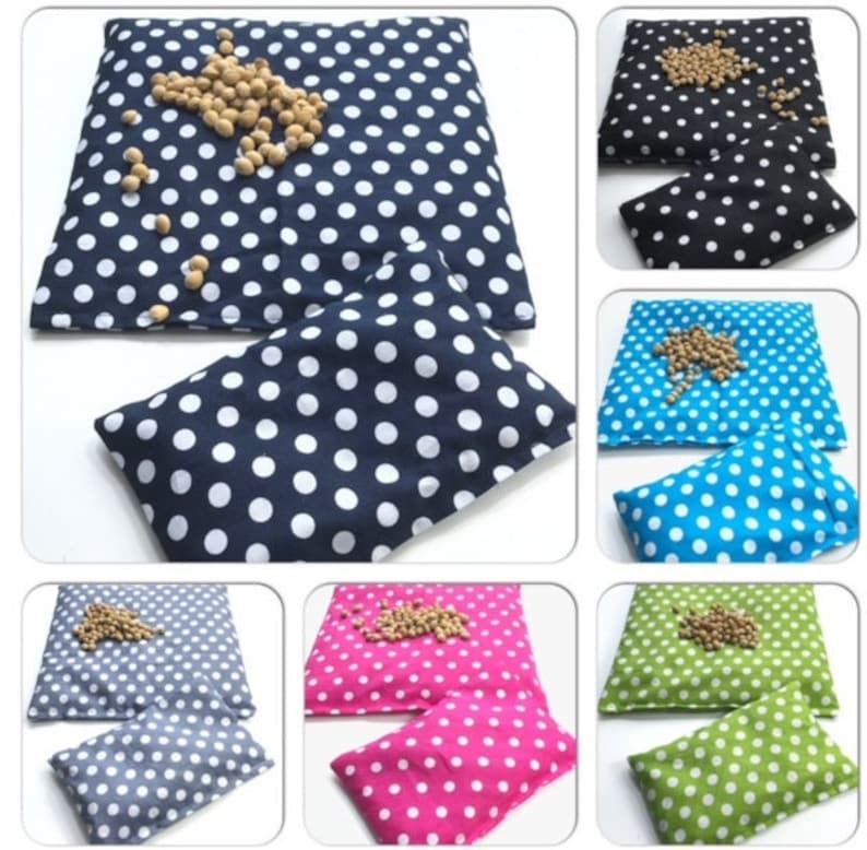 May include: Set of six polka dot heat packs in various colors, including navy blue, black, turquoise, pink, gray, and green. Each pack has a smaller matching pack inside. The larger packs are filled with beans and can be heated in the microwave.