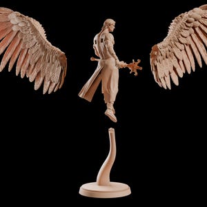 May include: A detailed sculpture of a figure with large, outstretched wings. The figure is in a flowing robe, holding a staff. The wings and figure are a light brown colour, set against a black background. The sculpture is on a stand.