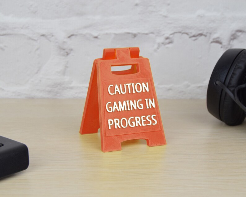 May include: Orange plastic caution sign with the text "CAUTION GAMING IN PROGRESS".