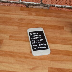 May include: A white smartphone with a black screen displaying a birthday message. The message reads "To Jessica I hope today is as special to you as you are to me. Happy birthday Love Michael x".