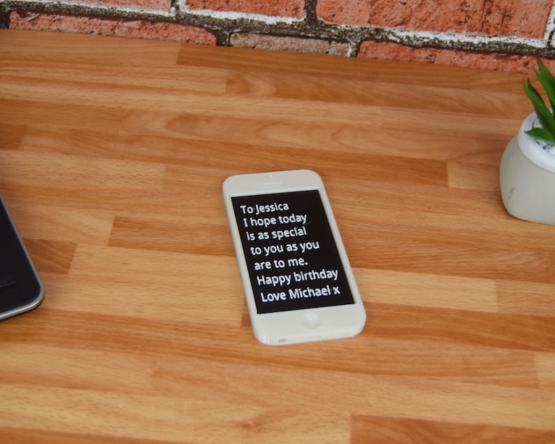 May include: A white smartphone with a black screen displaying a birthday message. The message reads "To Jessica I hope today is as special to you as you are to me. Happy birthday Love Michael x".