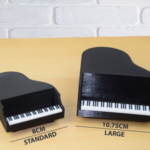 Puede incluir: Dos pianos de cola en miniatura negros, uno mide 8 cm y est&aacute; etiquetado como "STANDARD" y el otro mide 10,75 cm y est&aacute; etiquetado como "LARGE".