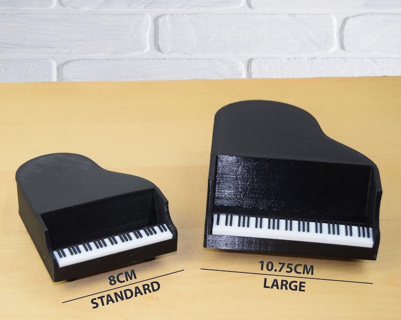 Puede incluir: Dos pianos de cola en miniatura negros, uno mide 8 cm y est&aacute; etiquetado como "STANDARD" y el otro mide 10,75 cm y est&aacute; etiquetado como "LARGE".