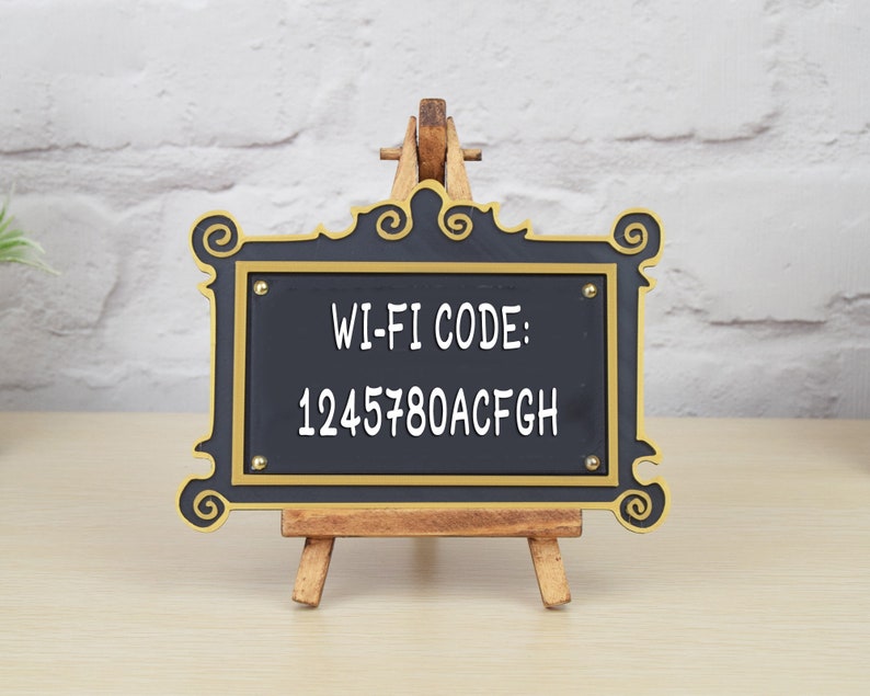May include: A black framed sign with gold accents on a wooden easel. The sign says "WI-FI CODE: 1245780ACFG" in white text.