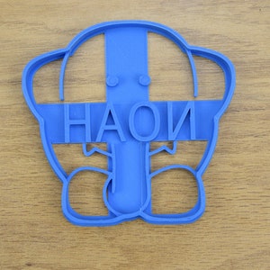 May include: Blue plastic cookie cutter shaped like a person with the word "HAOI" written across the front.