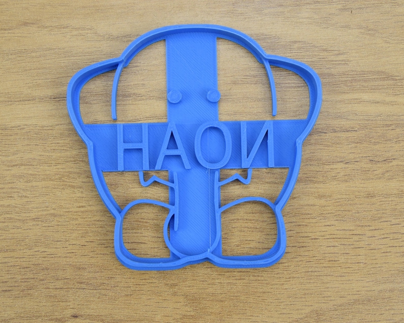 May include: Blue plastic cookie cutter shaped like a person with the word "HAOI" written across the front.