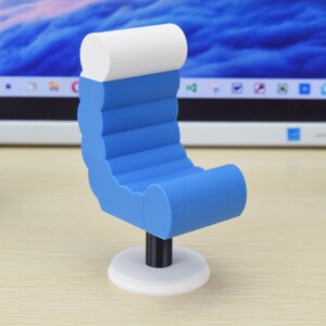 May include: A small blue and white chair with a rounded back and a white base. The chair is made of plastic and has a modern design.