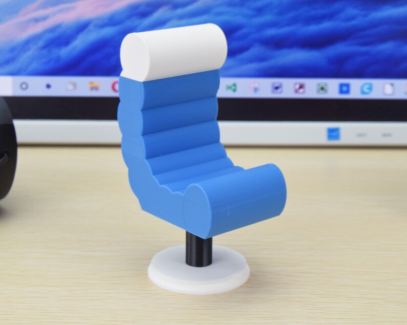 May include: A small blue and white chair with a rounded back and a white base. The chair is made of plastic and has a modern design.