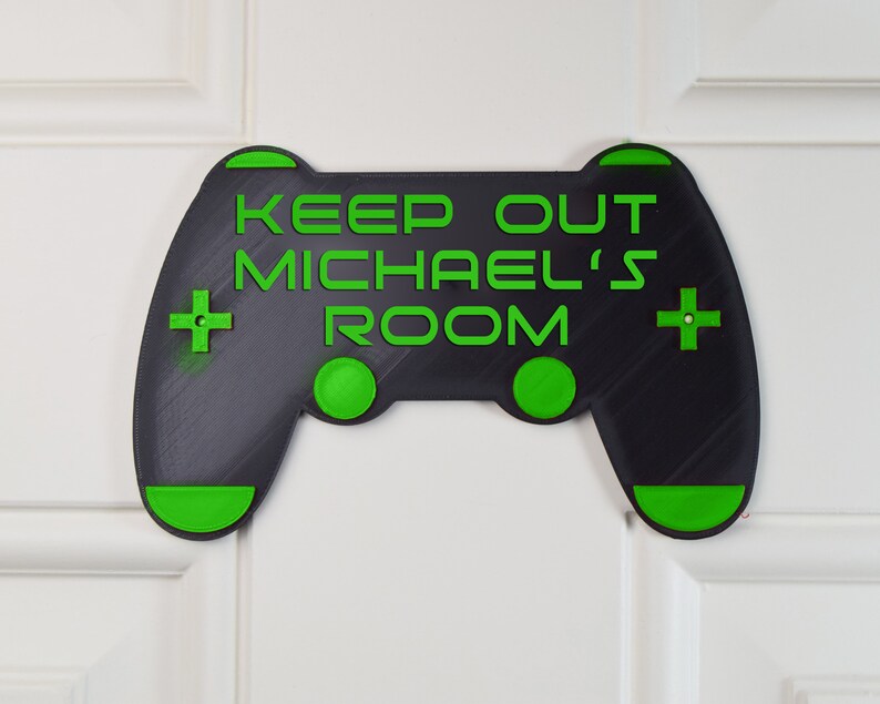 以下が含まれることがあります： 「Keep Out Michael's Room」という文字が書かれた、黒と緑のビデオゲームコントローラーの形をしたドアサイン。