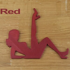 May include: Red silhouette of a woman in a reclining pose. The silhouette is made of a textured material.