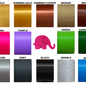 May include: A selection of 15 different colors of filament for 3D printing. The colors include gold, shimmer gold, shimmer copper, bronze, brown, pink, purple, green, dark green, silver, grey, black, marble, and blue. A pink elephant figurine is in the center of the image.