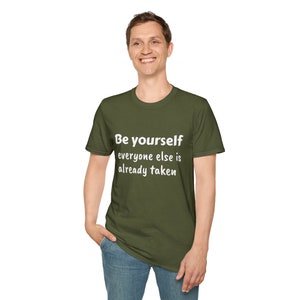 K&ouml;nnte beinhalten: Ein gr&uuml;nes T-Shirt mit dem Text "Be yourself everyone else is already taken" in Wei&szlig;.