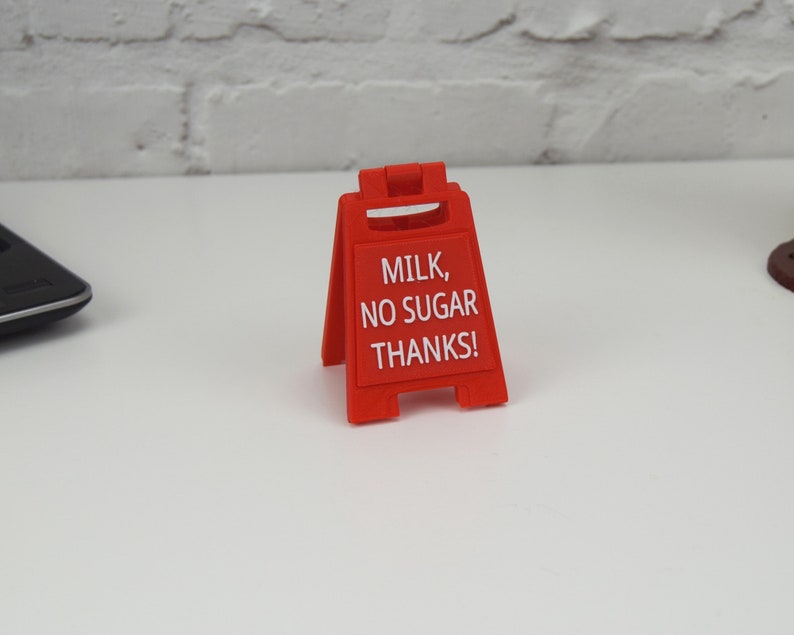 Może przedstawiać: Czerwony plastikowy znak z napisem "MILK, NO SUGAR THANKS!"