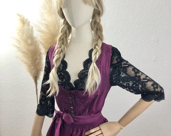 May include: A purple dirndl dress with a black lace bodice and a white blouse. The dress has a white apron and a bow at the waist.