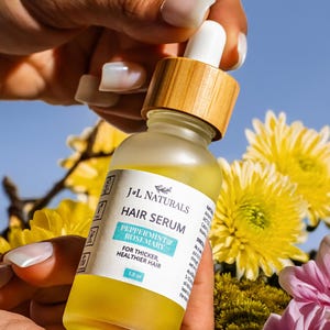 May include: A clear glass bottle with a bamboo lid and a dropper. The bottle contains a yellow liquid and has a white label that reads "J&L Naturals Hair Serum Peppermint & Rosemary For Thicker, Healthier Hair 1.0 oz".