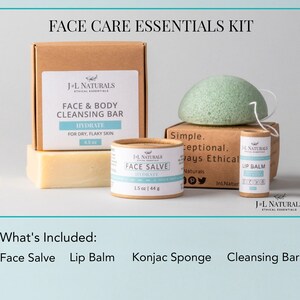 K&ouml;nnte beinhalten: Ein Gesichtspflege-Essentials-Set mit einer Reinigungsbar, einer Gesichtscreme, einem Lippenbalsam und einem Konjac-Schwamm. Die Produkte sind in braunen Pappr&ouml;hrchen und -boxen verpackt, auf denen der Markenname "J-L Naturals Ethical Essentials" aufgedruckt ist. Das Set wird vor einem hellblauen Hintergrund pr&auml;sentiert.