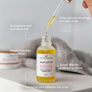 May include: A clear glass bottle with a yellow liquid inside. The bottle is labeled "J+L Naturals Hair Serum Lavender & Rose Geranium" and "For Color Treated & Damaged Hair". The bottle is sitting on a white surface with a dropper bottle and a white towel in the background.