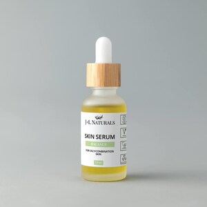 May include: A clear glass bottle with a bamboo lid and a dropper top. The bottle contains a yellow liquid and has a white label that reads "J+L NATURALS SKIN SERUM BALANCE FOR OILY/COMBINATION SKIN 1.0 fl oz".
