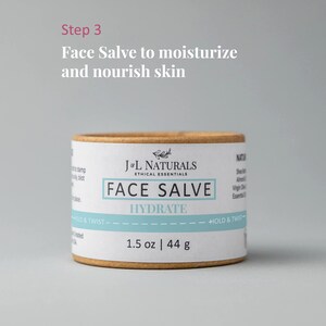 K&ouml;nnte beinhalten: Eine braune Pappr&ouml;hre mit einem wei&szlig;en Etikett, auf dem "J&L Naturals Ethical Essentials Face Salve Hydrate 1.5 oz | 44 g" steht. Die R&ouml;hre ist an beiden Enden mit "Hold & Twist" beschriftet.