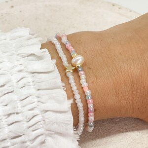 Two elastic bracelets made of seed beads, a freshwater pearl and a star, pastel-colored bracelet set