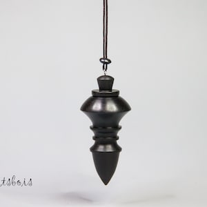 Pendule divinatoire en bois d'Ebène (Cameroun) Pendule lesté . Long 6 cm-ø maxi 2,8 cm-ø  mini 1,6 cm. Poids 20 grammes