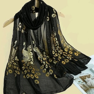 May include: Black sheer scarf with gold embroidered peacocks and peacock feathers.
