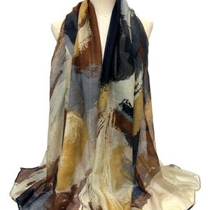 May include: A beige, brown, gray, and black abstract print scarf. The scarf is made of a soft, lightweight fabric and is perfect for adding a touch of style to any outfit.
