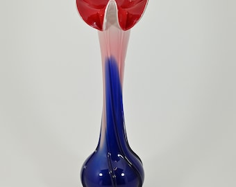 May include: A tall glass vase with a flared opening. The vase is blue, pink, and red with a swirl design.
