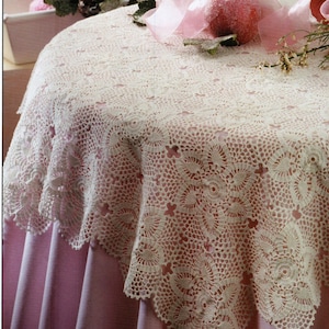 May include: A white crocheted tablecloth with a delicate floral pattern. The tablecloth is laid on a pink table and decorated with pink and white ornaments.