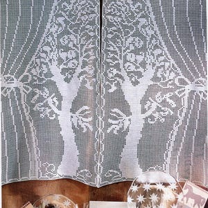 Peut inclure: Une paire de rideaux en crochet blanc avec un motif d'arbre. Les rideaux sont suspendus à une fenêtre et sont décorés d'une bordure en crochet blanc.
