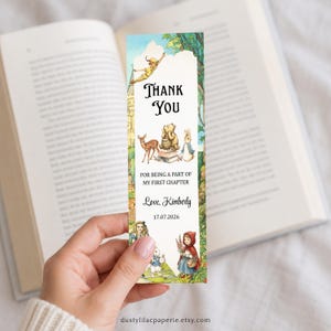 May include: A rectangular paper bookmark featuring watercolor illustrations of classic storybook characters including Peter Pan, Winnie the Pooh, a deer, Alice, and Little Red Riding Hood. The text reads Thank You For Being A Part Of My First Chapter, Love, Kimberly, 17.07.2026.