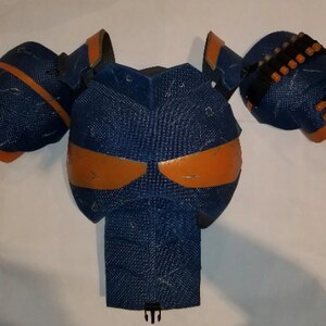 May include: Blue and orange padded armour for cosplay or costume. The armour is made of foam and has a textured surface.